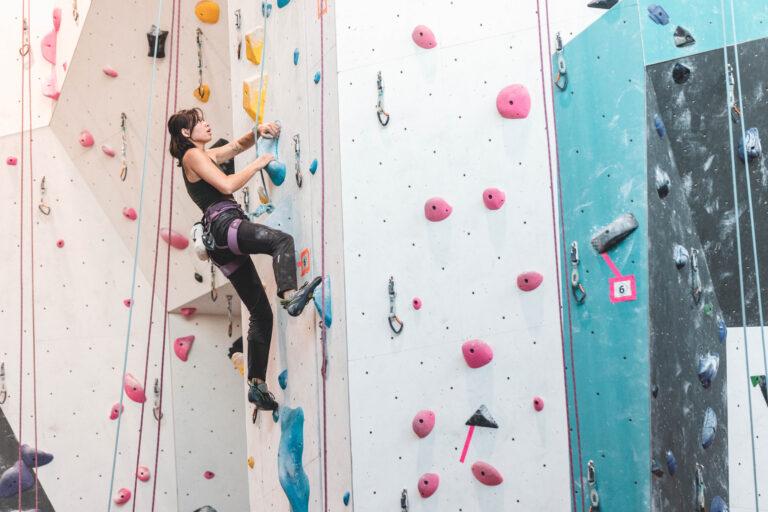 Climber on a tall top rope wall at Alpine Climbing in Ripon, CA